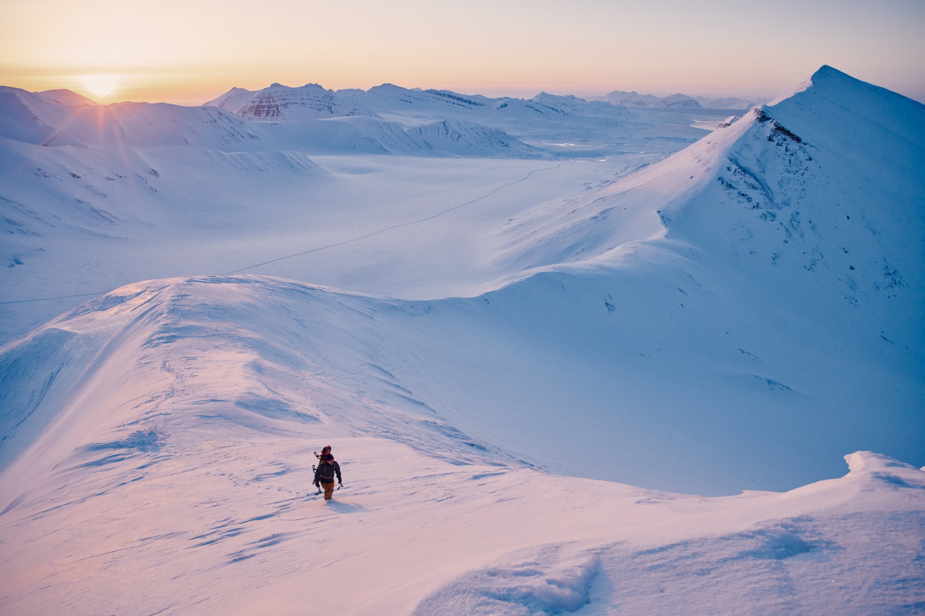 Soloppgang over snødekte fjell på Svalbard